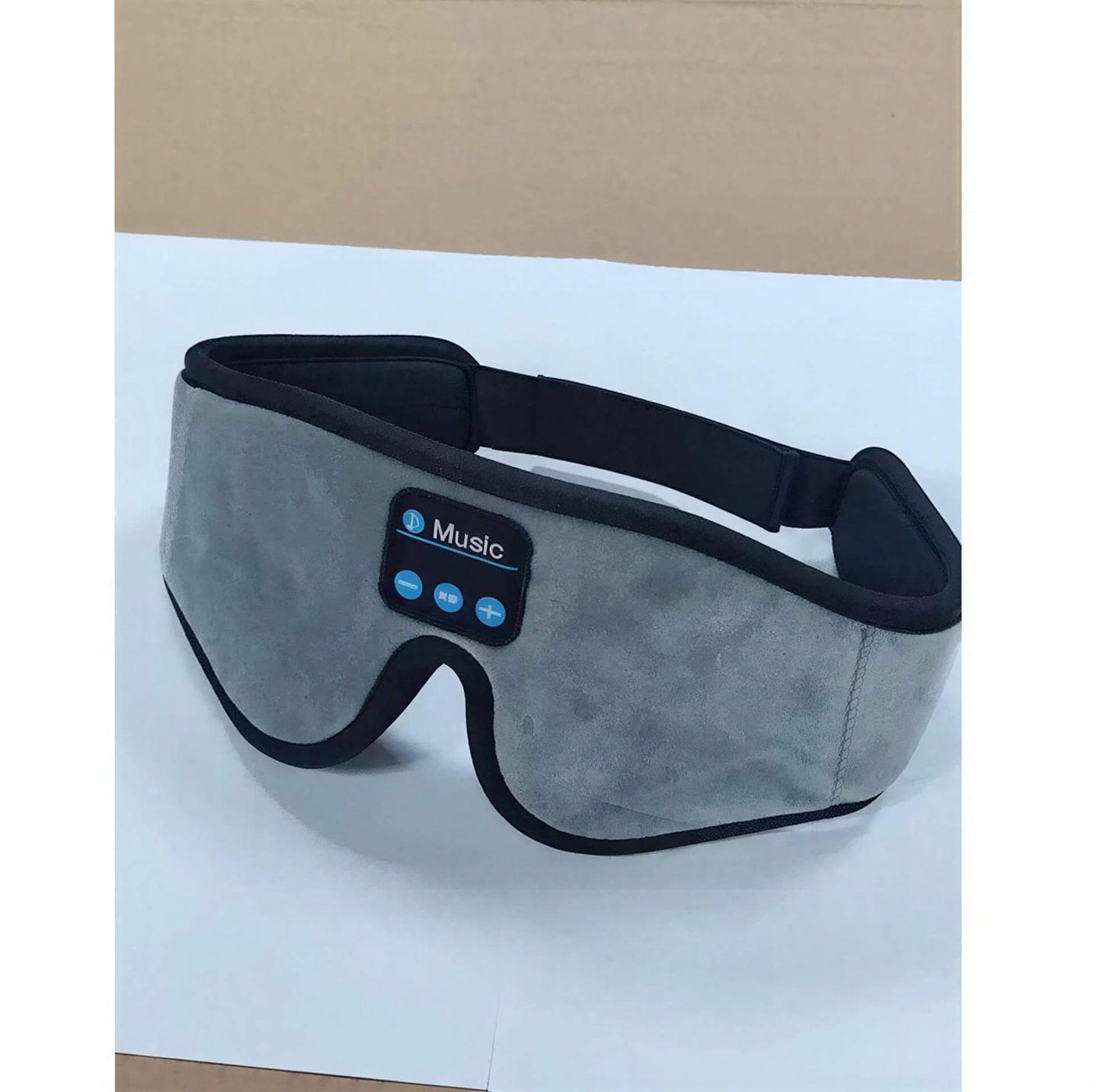 Gray 3D eye mask with Bluetooth controls for music, featuring a soft fabric exterior and adjustable strap.