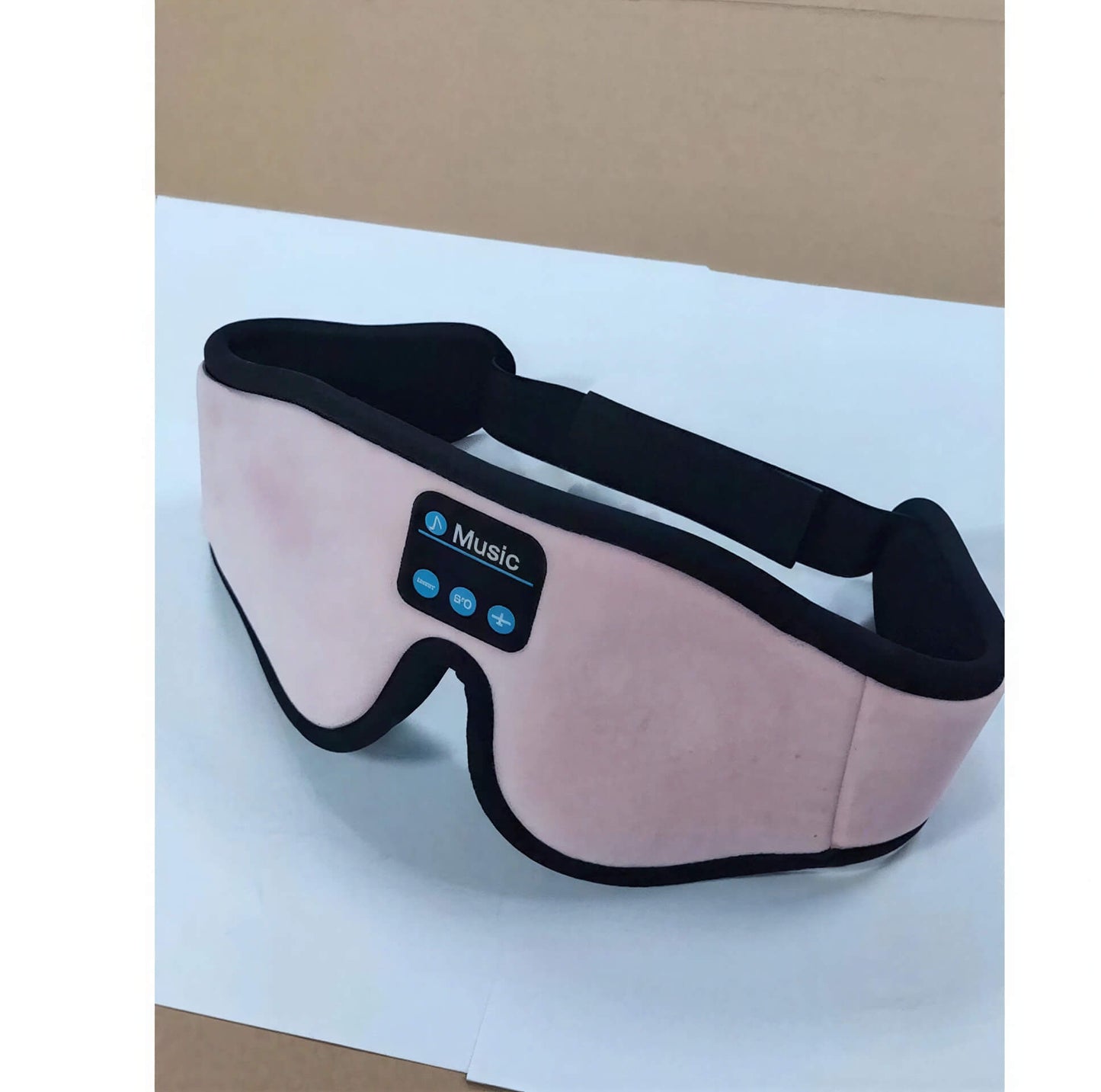 3D eye mask in soft pink fabric with Bluetooth controls for music playback, designed for comfort and relaxation.